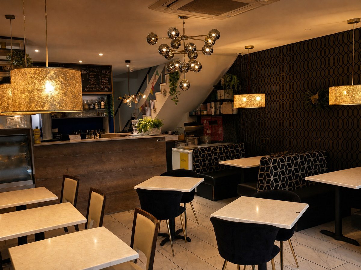 Inside Dine & Dessert Kirkham: black and gold patterned walls, marble tables and warm lighting